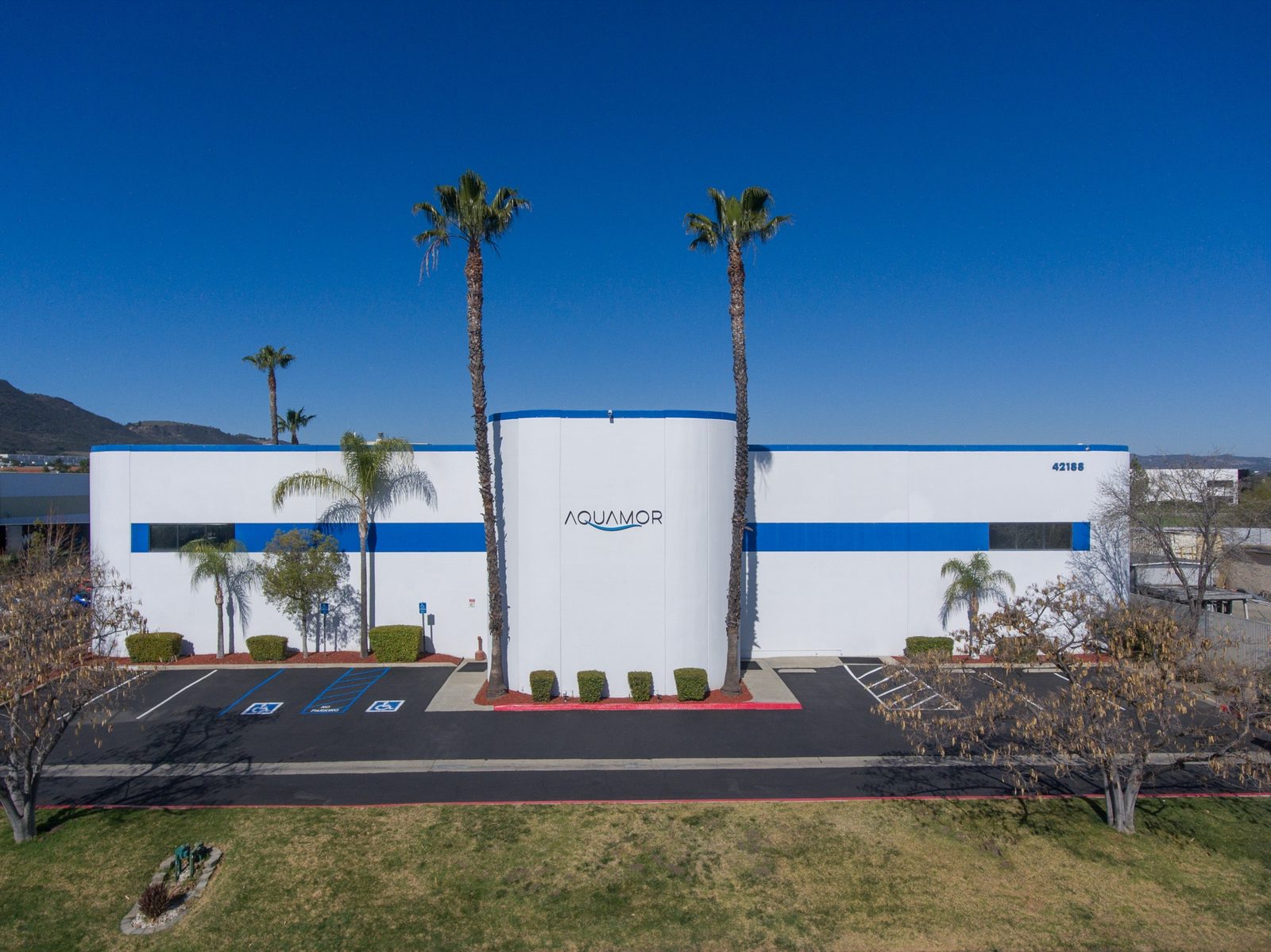 Aquamor's Temecula, California facility, white-and-blue building with the Aquamor wordmark under a clear sky